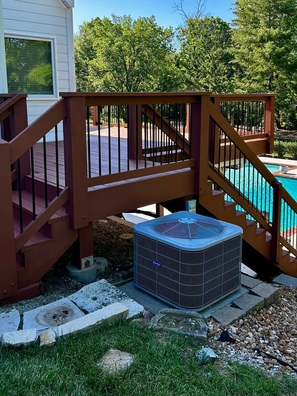 The same deck after restoration - deck boards, stairs, railings and posts recoated in a deep barn red